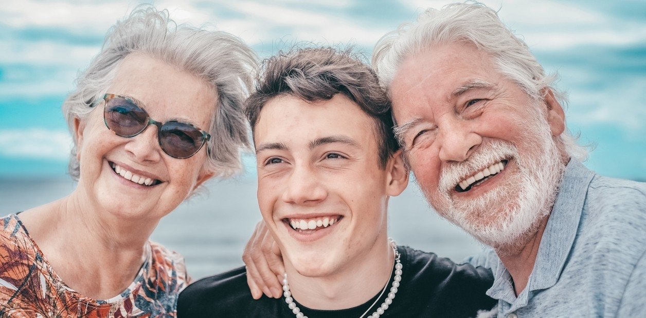 A teenager with grandparents, smiling together